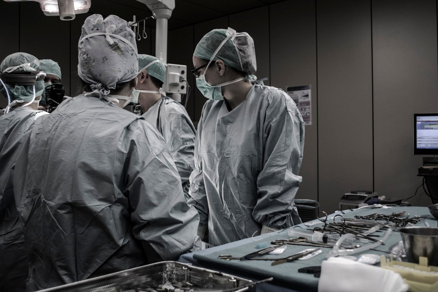 Scrubbed team around an instrument tray during a live demonstration